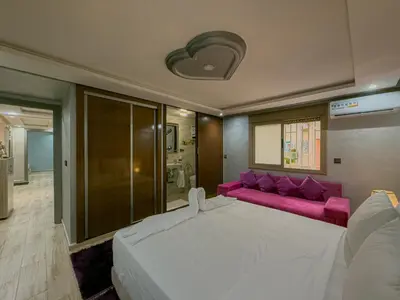 a bedroom with a large bed and a pink couch at Essalmi Duplex Apartment in Marrakech in Marrakech