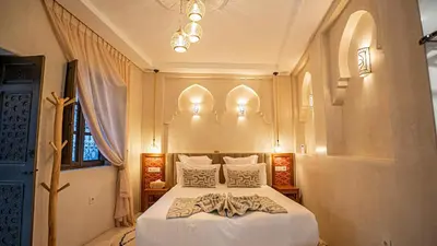 a bedroom with a bed with a robe on it at Riad Le Soleil Rouge in Marrakech