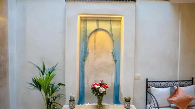 a room with a painting of a head on the wall at Riad Le Soleil Rouge in Marrakech