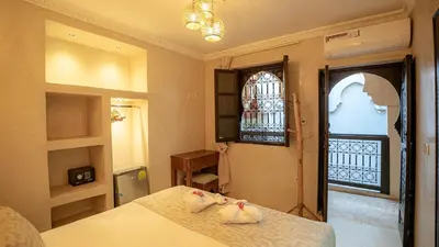 a bedroom with a bed and a window at Riad Le Soleil Rouge in Marrakech