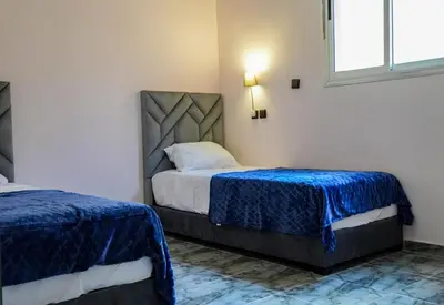 a bedroom with two beds and a window at Appartement Moderne a Marrakech - 2 Chambres, Salon et Cuisine Equipee in Marrakech