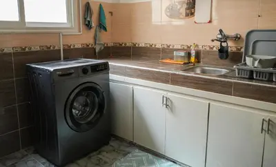 a kitchen with a washing machine next to a sink at Appartement Moderne a Marrakech - 2 Chambres, Salon et Cuisine Equipee in Marrakech