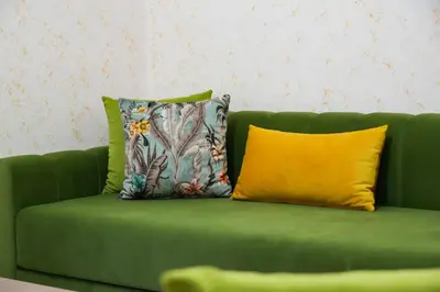 a green couch with two pillows on it at Appartement Moderne a Marrakech - 2 Chambres, Salon et Cuisine Equipee in Marrakech