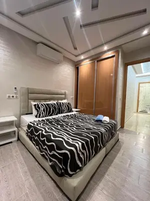 a bedroom with a large bed with a zebra blanket at Des appartements conçus pour votre confort in Marrakech