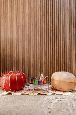 two pillows and a tray on a table next to a wooden wall at Modern & Refined Apartment Majorelle Downtown in Marrakech