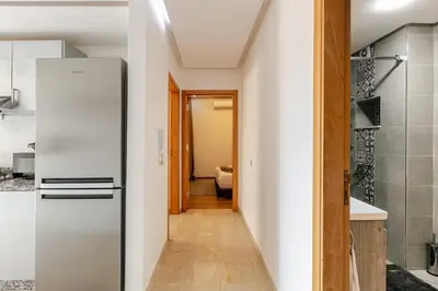 a kitchen with a refrigerator and a hallway at Modern & Refined Apartment Majorelle Downtown in Marrakech