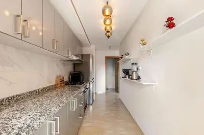 a kitchen with white cabinets and marble counter tops at Modern & Refined Apartment Majorelle Downtown in Marrakech
