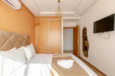 a bedroom with a bed and a flat screen tv at Modern & Refined Apartment Majorelle Downtown in Marrakech