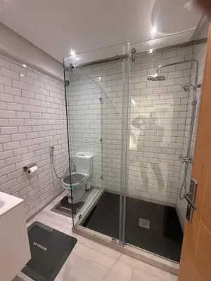 a bathroom with a glass shower with a toilet at Residence miraj in Marrakech