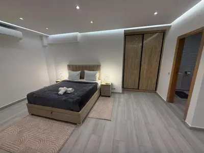 a bedroom with a large bed and a wooden floor at Residence miraj in Marrakech