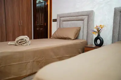 a bedroom with two beds and a vase of flowers at Bel Appartement 2 Chambres Confort et Emplacement Idéal in Marrakech