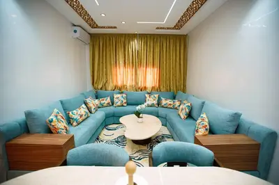 a living room with a blue couch and a table at Bel Appartement 2 Chambres Confort et Emplacement Idéal in Marrakech