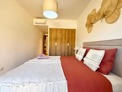 a bedroom with a bed with red and white pillows at Noria Golf Marrakeck 2 chambres jardin in Marrakech