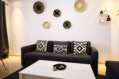 a living room with a couch and plates on the wall at Noria Golf Marrakeck 2 chambres jardin in Marrakech