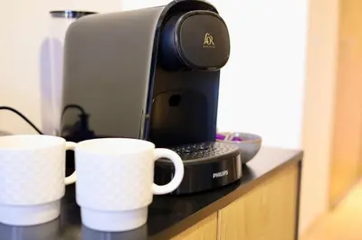 a coffee maker and two cups on a counter at Noria Golf Marrakeck 2 chambres jardin in Marrakech