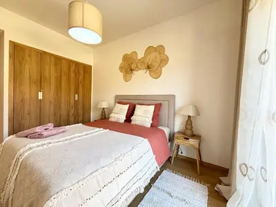 a bedroom with a bed with a flower on the wall at Noria Golf Marrakeck 2 chambres jardin in Marrakech