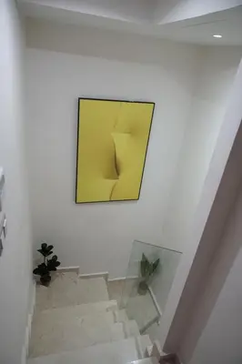 a staircase with a yellow painting on the wall at Mamounia loft by M&I in Marrakech