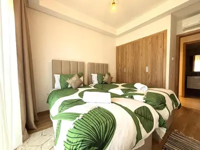 a bedroom with two beds with green and white blankets at Marrakech Noria Golf, cosy appartement 2 chambres in Marrakech