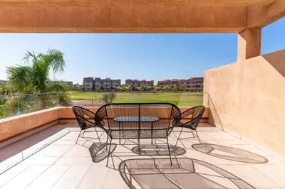 a patio with a table and chairs on a balcony at Luxury Villa Private Pool & Golf View 7 min to center in Marrakech