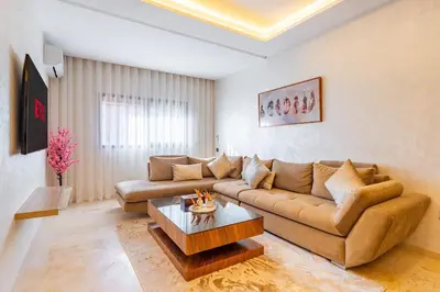a living room with a couch and a coffee table at AFCON Stay Gueliz 2BR & Pool, Parking & Wi-Fi in Marrakech