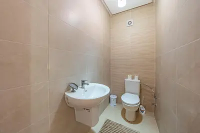 a bathroom with a white toilet and a sink at AFCON Stay Gueliz 2BR & Pool, Parking & Wi-Fi in Marrakech