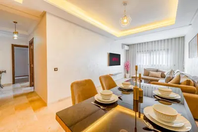 a living room with a dining table and a couch at AFCON Stay Gueliz 2BR & Pool, Parking & Wi-Fi in Marrakech