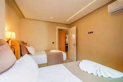 a hotel room with two beds and a hallway at Gueliz Prime 2BR Perfect Central Stay in Marrakech in Marrakech