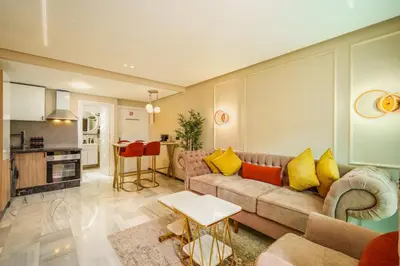 a living room with a couch and a kitchen at Gueliz Prime 2BR Perfect Central Stay in Marrakech in Marrakech