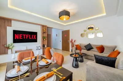 a living room with a couch and a table at Cozy Gueliz Apartment , Access to Pool , Central Location in Marrakech
