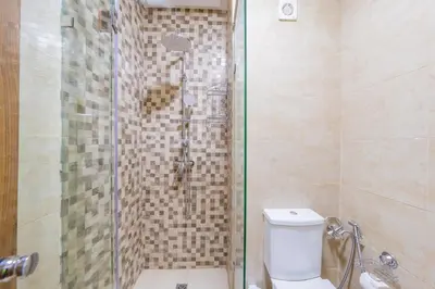 a bathroom with a glass shower with a toilet at Cozy Gueliz Apartment , Access to Pool , Central Location in Marrakech