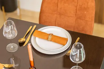 a napkin on a plate on a table with wine glasses at Cozy Gueliz Apartment , Access to Pool , Central Location in Marrakech