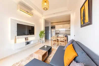 a living room with a blue couch and a table at Cozy 1BR Apt Fast WiFi Peaceful Spot n Center of Gueliz Marrakech in Marrakech