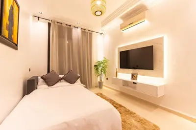 a bedroom with a large bed and a flat screen tv at Cozy 1BR Apt Fast WiFi Peaceful Spot n Center of Gueliz Marrakech in Marrakech