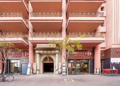a large pink building with a tree in front of it at Cozy 1BR Apt Fast WiFi Peaceful Spot n Center of Gueliz Marrakech in Marrakech