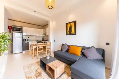 a living room with a couch and a table at Cozy 1BR Apt Fast WiFi Peaceful Spot n Center of Gueliz Marrakech in Marrakech