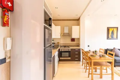 a kitchen and dining room with a table and chairs at Cozy 1BR Apt Fast WiFi Peaceful Spot n Center of Gueliz Marrakech in Marrakech