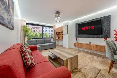 a living room with a red couch and a tv at Modern 1BR , Balcony & WiFi & 2min Eden in Marrakech
