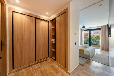 a room with wooden closet doors in a house at Modern 1BR , Balcony & WiFi & 2min Eden in Marrakech