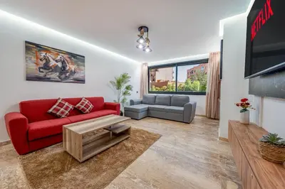 a living room with a red couch and a tv at Modern 1BR , Balcony & WiFi & 2min Eden in Marrakech