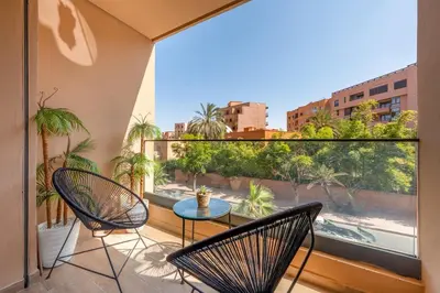 a balcony with two chairs and a table and a window at Modern 1BR , Balcony & WiFi & 2min Eden in Marrakech