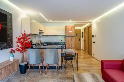 a kitchen with a table and chairs and a red couch at Modern 1BR , Balcony & WiFi & 2min Eden in Marrakech
