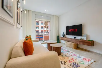 a living room with a couch and a tv at Modern 1BR , Cinema & Xbox , Central Guéliz in Marrakech