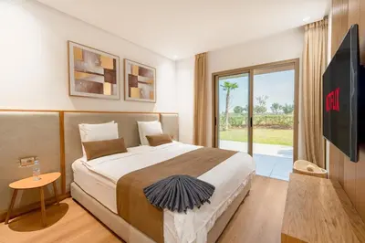a hotel room with a bed and a tv at Spacious 2BR , Pool & Garden , Golf View , Fast WiFi in Marrakech
