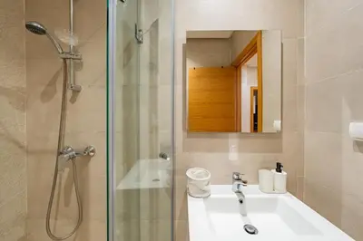 a bathroom with a shower and a sink and a mirror at Spacious 2BR , Pool & Garden , Golf View , Fast WiFi in Marrakech
