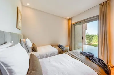 a bedroom with two beds and a balcony at Spacious 2BR , Pool & Garden , Golf View , Fast WiFi in Marrakech