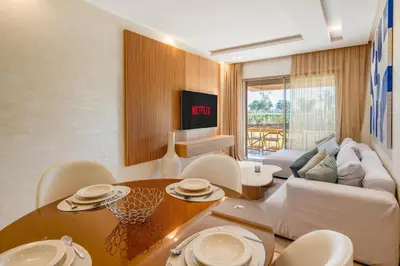 a living room with a table and a couch at Spacious 2BR , Pool & Garden , Golf View , Fast WiFi in Marrakech