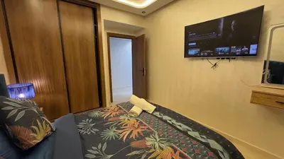 a room with a couch and a flat screen tv at Appartement 3 chambres jaccuzi in Marrakech