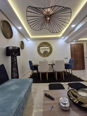 a living room with a table and chairs and a ceiling at Appartement 3 chambres jaccuzi in Marrakech