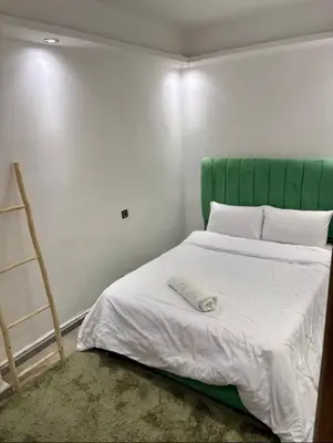 a bed with a green headboard in a room at Madame plaza in Marrakech
