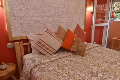 a bedroom with a bed with colorful pillows at Stylish appartment,5min to airport fiber&netflix in Marrakech